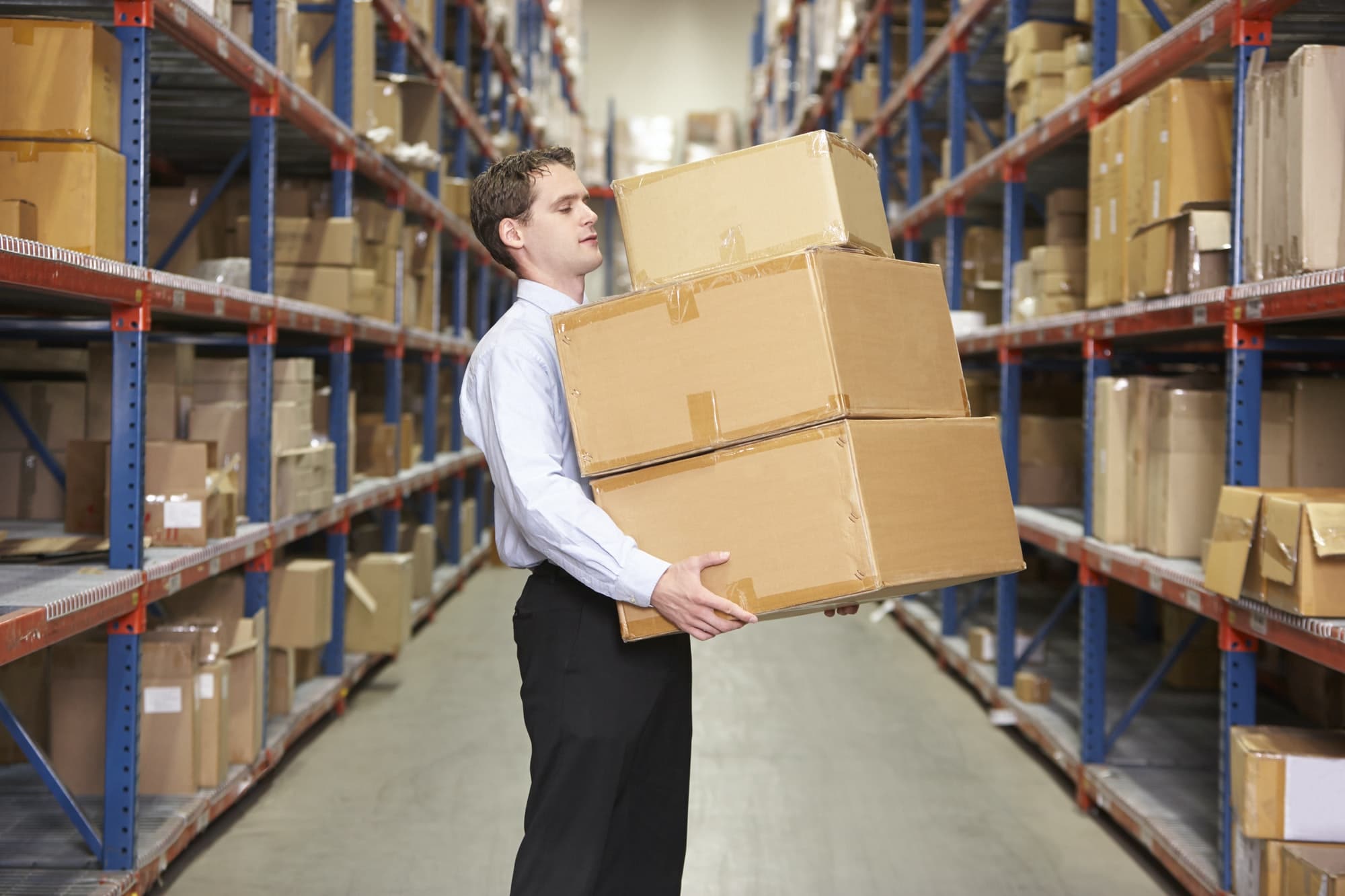 Man Carrying Boxes In Warehouse